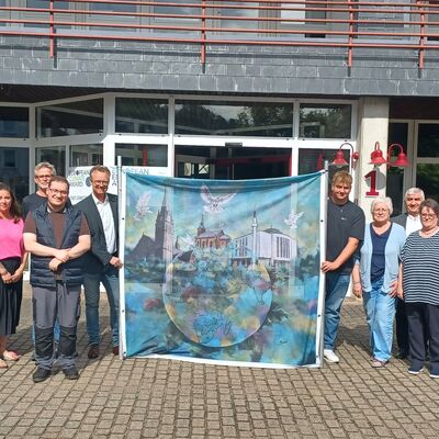 Foto � Stadt Lennestadt. Die Mitglieder des Arbeitskreises Integration unter dem Vorsitz von Nedim Kalembasi (7.v.r.), B�rgermeister Tobias Puspas (8.v.l.) sowie Christa Maria J�rgens (musikalische Gesamtleitung (5.v.r.) freuen sich auf das interreligi�se Friedensgebet beim Stadtfestsonntag